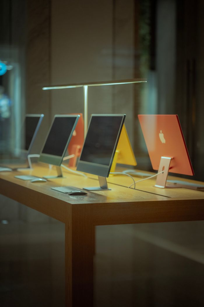 services-04 Vibrant desktop computers showcased on a wooden table in modern retail environment.