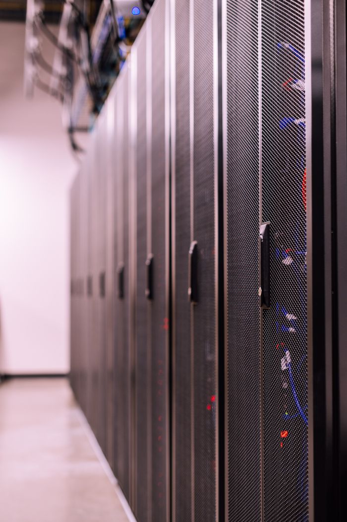 about-us-01 Row of similar lockers with various optic fiber cables in modern data server room
